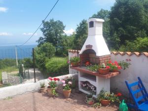 a garden with a brick oven and potted plants at Gemütliche Ferienwohnung Mit Toller Aussicht in Dobreć