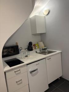 une petite cuisine avec un évier et un micro-ondes dans l'établissement Duplex Haut de Gamme Centre Montauban, à Montauban 2 autres photos