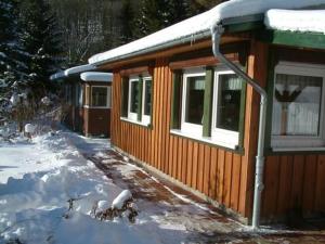 a small cabin with snow on top of it at Ferienhaus Mit Bergblick in Harztor +4 photos
