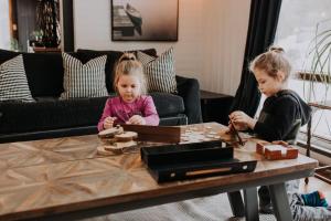 zwei kleine Mädchen spielen um einen Couchtisch in der Unterkunft Le Cozy de St-Come - Lake front- boats in Saint Come + 55 Fotos