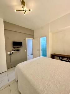 a bedroom with a white bed and a television at 957 golden fortaleza frente mar in Fortaleza +3 photos