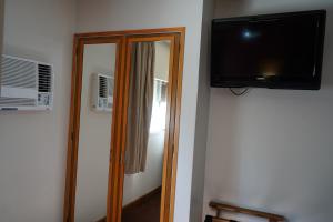 a mirror and a television in a room at Hotel coventry in Santiago del Estero