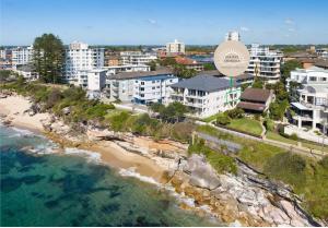 an aerial view of a beach with buildings and the ocean at North Facing Seaside Apartment in Cronulla