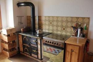 uma cozinha com um fogão antigo num quarto em Alpe Monte Massella em Poschiavo