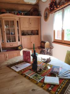 uma cozinha com uma mesa com uma garrafa de vinho em Alpe Monte Massella em Poschiavo