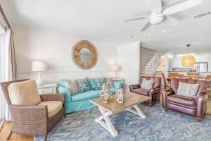 ein Wohnzimmer mit einem blauen Sofa und Stühlen in der Unterkunft Blue Tide 6B in Inlet Beach