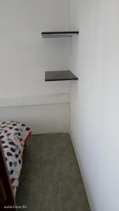 Zimmer mit einer weißen Wand und einem Regal in der Unterkunft lo de andres y marina in Arroyo de Los Patos