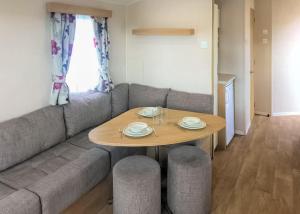 a living room with a table and a couch at The Chase Holiday Park in Winthorpe