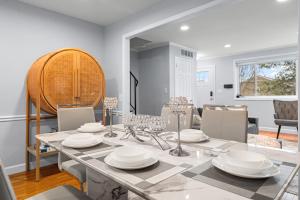 - une salle à manger avec une table et des plats blancs dans l'établissement Modern 4BR Getaway 3 Min to OldTown Walk to Metro, à Alexandria