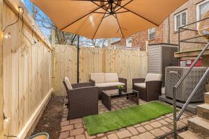 un patio avec un parasol, des chaises et une table dans l'établissement Modern 4BR Getaway 3 Min to OldTown Walk to Metro, à Alexandria