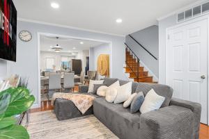 un salon avec un canapé gris avec des oreillers dans l'établissement Modern 4BR Getaway 3 Min to OldTown Walk to Metro, à Alexandria