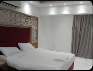 une chambre avec un grand lit blanc et une fenêtre dans l'établissement الغردقه قريه فنادير باى, à Hurghada 12 autres photos