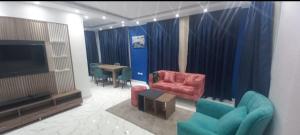 Il comprend un salon doté d'une télévision, de chaises et d'une table. dans l'établissement الغردقه قريه فنادير باى, à Hurghada