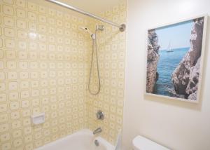 ein Badezimmer mit Dusche und einem Bild an der Wand in der Unterkunft 26th Floor Ocean-View Waikiki Condo 26th Floor, 2 Queens, Free Parking in Honolulu