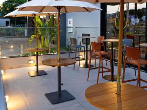 a restaurant with tables and chairs and umbrellas at ibis Barra do Garças in Barra do Garças