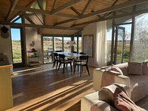 a living room with a couch and a table with chairs at Summer House With Fields And Fjord Views in Thyholm
