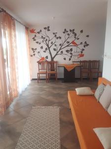 a living room with a tree with birds on the wall at Charmante Wohnung Adriana F in Dobreć