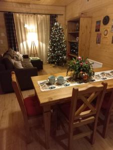 ein Wohnzimmer mit einem Tisch und einem Weihnachtsbaum in der Unterkunft Domek Sol Wilcza Zagroda in Kudowa-Zdrój
