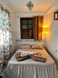 Schlafzimmer mit einem Bett und einem Fenster in der Unterkunft Hostel Uai in Ouro Preto