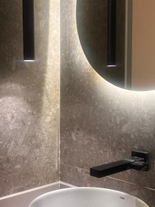 łazienka z umywalką i okrągłym lustrem w obiekcie Luxurious studio next to Confeitaria Colombo w mieście Rio de Janeiro