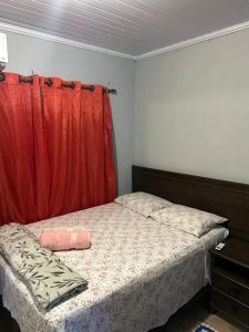 ein Schlafzimmer mit einem Bett mit einem roten Vorhang in der Unterkunft casa cristal in Alto Paraíso de Goiás