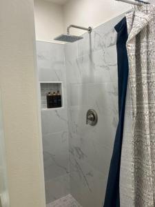 圣巴巴拉Goodland Green House的带淋浴的浴室，配有蓝色浴帘 更多11张照片