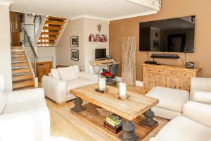 un salon avec une table et une télévision dans l'établissement Brecon Beacons Welsh Countryside Home, à Merthyr Tydfil