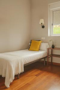 a bed with a yellow pillow on it in a room at Casa Musiú: vistas únicas y excelente ubicación! in Las Nieves