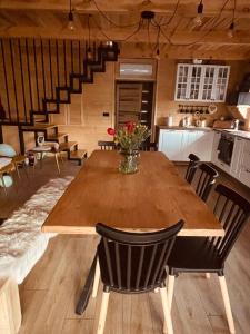 a wooden table with a vase of flowers on it at Agroturystyka AKPólko in Biała Podlaska