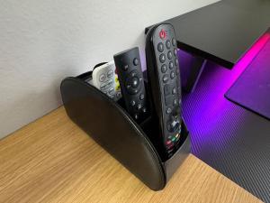 drei Fernbedienungen auf einem Schreibtisch in der Unterkunft A private master room in modern complex shared apartment in Lawrenceville 