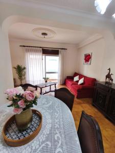 un salon avec une table et un canapé rouge dans l'établissement Jardim das Laranjeiras Apartment, à Bicas