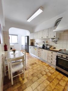 une cuisine avec une table et une cuisinière et une table et des chaises dans l'établissement Jardim das Laranjeiras Apartment, à Bicas