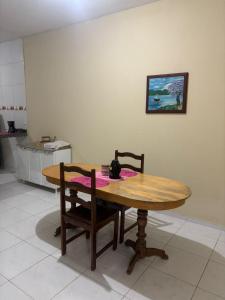 a wooden table and two chairs in a kitchen at Casa de temporada in Tianguá
