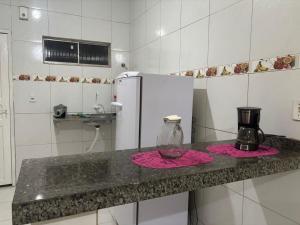a kitchen with a counter top with a refrigerator at Casa de temporada in Tianguá