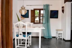 ein weißer Tisch und Stühle in einem Raum mit einem Fenster in der Unterkunft Appartement in Uga mit Schönem Garten - b48511 in Uga