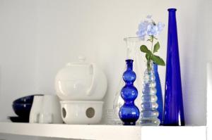 ein Regal mit mehreren blauen Glasvasen darauf in der Unterkunft Appartement in Uga mit Schönem Garten - b48511 in Uga