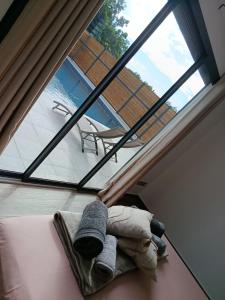 un animal en peluche posé sur un lit à côté d'une fenêtre dans l'établissement Villa 4 étoiles Bon Air, à Bouillante