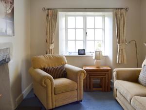 a living room with a chair and a window at Breasty Haw in Grizedale