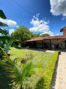 a house with a garden and a palm tree at Finca Hotel Villa Nieves in Tuluá