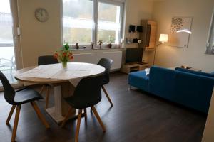 ein Wohnzimmer mit einem Tisch und einem blauen Sofa in der Unterkunft moderne Ferienwohnung " Ober Langengarten" mit separatem Wellnessbereich, direkt am Radweg in Pittenbach