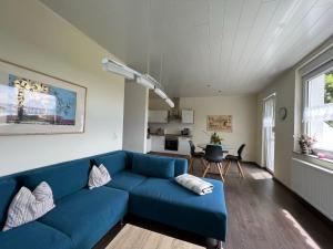 ein Wohnzimmer mit einem blauen Sofa und einem Tisch in der Unterkunft moderne Ferienwohnung " Ober Langengarten" mit separatem Wellnessbereich, direkt am Radweg in Pittenbach