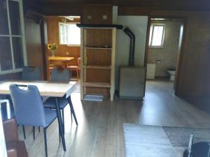 une cuisine avec une table, des chaises et une cuisinière dans l'établissement Ferien Cottage Flüehblüemli, à Stechelberg