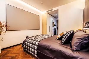 a bedroom with a bed and a large screen at Shanghai Hills&Rais Apartment - 100-inch Projector - Near Nanjing Road Pedestrian Street in Shanghai