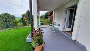 un balcón de una casa con una mesa y flores en Angenweg 2, en Entlebuch