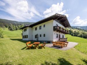 a house with two picnic tables in front of it at Schwoichbauer II in Saalbach-Hinterglemm