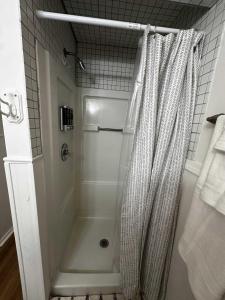 eine Dusche mit Duschvorhang im Bad in der Unterkunft South Side Resort - Very Close Derby Turnpike Dtn in South Seneca Gardens