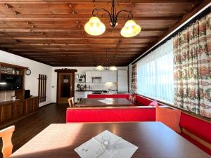 un salon avec un canapé rouge et une table dans l'établissement Schwoichbauer, à Saalbach-Hinterglemm