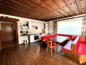 un salon avec un canapé rouge et une table dans l'établissement Schwoichbauer, à Saalbach-Hinterglemm 11 autres photos