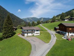 une maison sur une colline à côté d'une route dans l'établissement Schwoichbauer II, à Saalbach-Hinterglemm