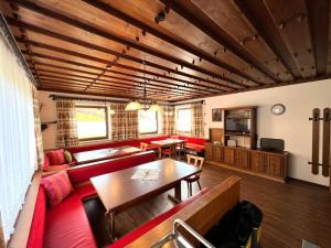 un salon avec un canapé rouge et une table dans l'établissement Schwoichbauer, à Saalbach-Hinterglemm